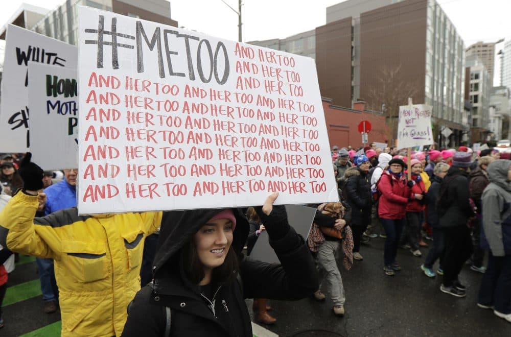 A marcher carries a sign with the popular Twitter hashtag #MeToo used by people speaking out against sexual harassment as she takes part in a Women's March in Seattle, Saturday, Jan. 20, 2018. On the anniversary of President Donald Trump’s inauguration, people participating in rallies and marches in the U.S. and around the world Saturday denounced his views on immigration, abortion, LGBT rights, women's rights and more. (AP Photo/Ted S. Warren)