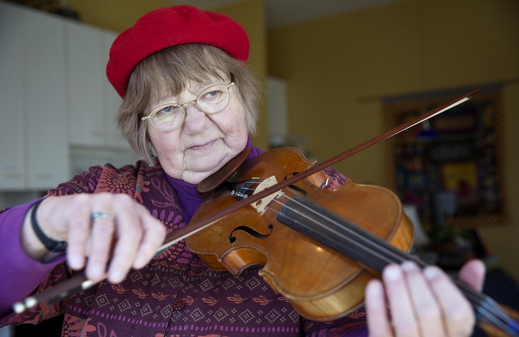 Betty Hauck, a musician suffering from hearing loss, plays her violin at home in Cambridge, Mass. (Robin Lubbock/WBUR)