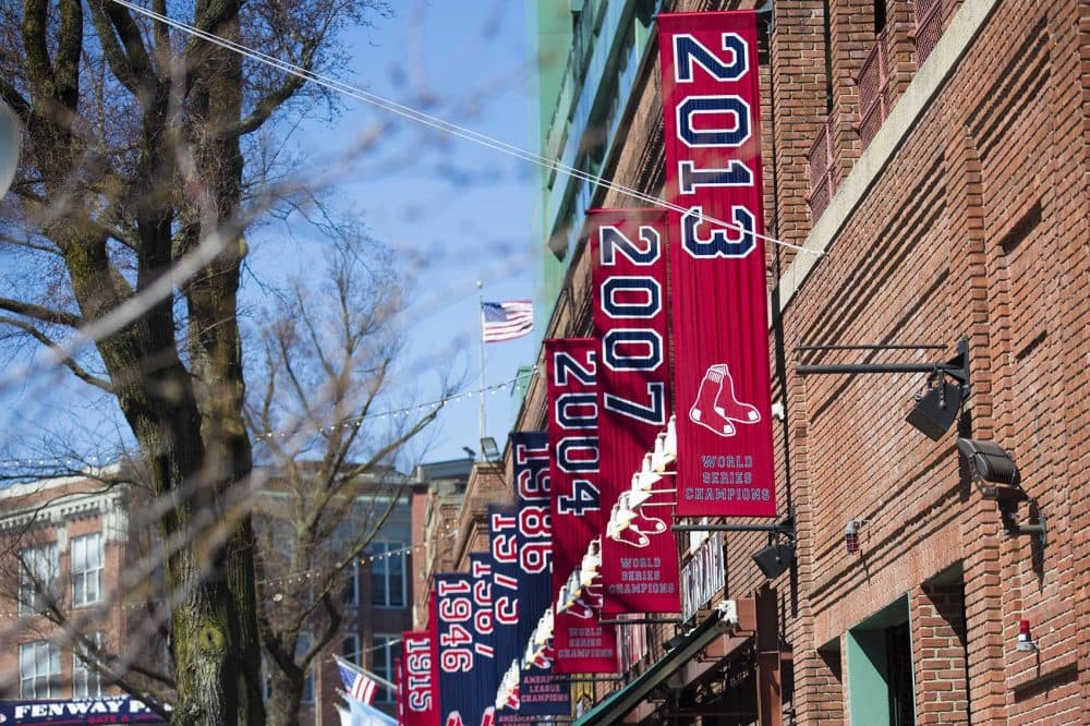 The Red Sox World Series banners hang on the outside of Fenway Park on Yawkey Way. (Jesse Costa/WBUR)