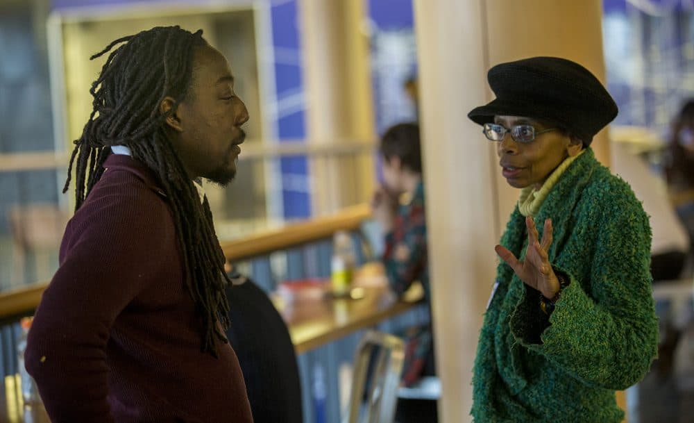 Kofi Callender, Executive Director of Smarter in the City speaks with Andrea M. Payne of the Timothy Smith Network at the investor pitch meeting held at the Roxbury Innovation Center,. (Jesse Costa/WBUR)