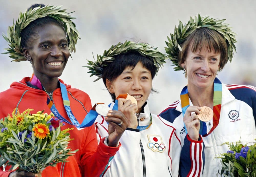 Deena Kastor (far right) of the U.S. stands with gold medalist Mizuki Noguchi of Japan and silver medalist Catherine Ndereba of Kenya on the podium of the women's marathon at the Olympic Stadium on Aug. 23, 2004, during the Summer Olympic Games athletics competitions in Athens, Greece. (Toshifumi Kitamura/AFP/Getty Images)
