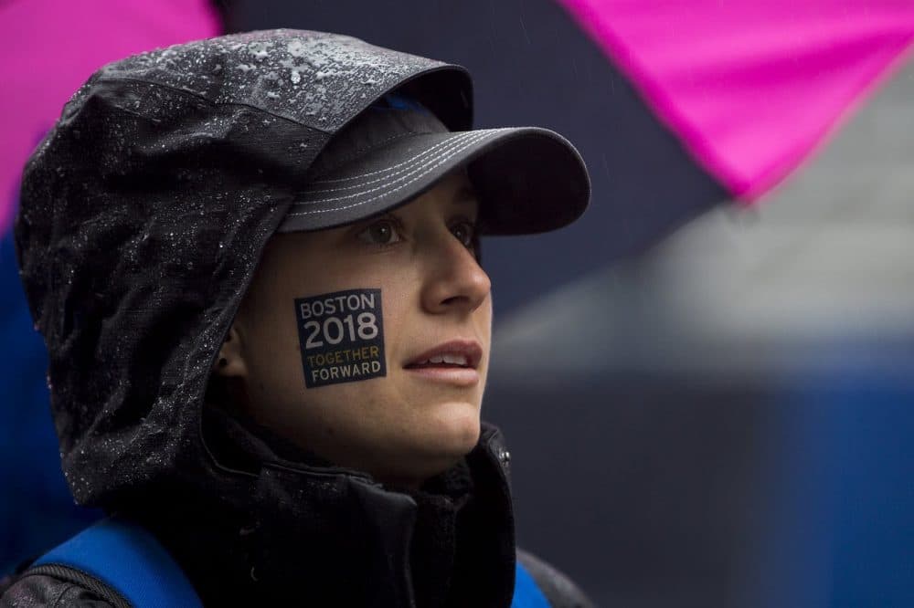 A spectator watches the broadcast of the race on a big screen on Exeter Street. (Jesse Costa/WBUR)