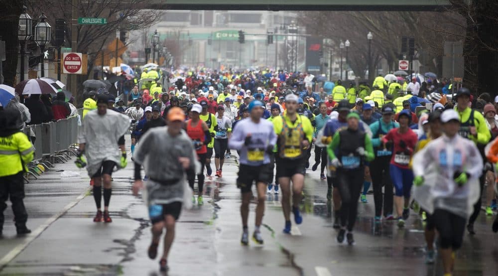 Marathoners pour out of Kenmore Square down Commonwealth Avenue. (Jesse Costa/WBUR)