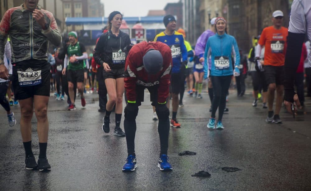 Gregory Scanlon stops to take a breather after finishing the Boston Marathon. (Jesse Costa/WBUR)