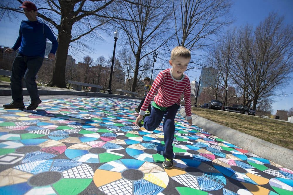 Matthew Grubb, 8, his father Dan and brother Andrew, 5, try to only step on the yellow sections on the not-yet-completed installation. (Jesse Costa/WBUR)