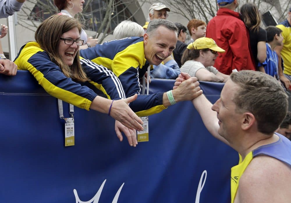 Denise and Bill Richard, parents of Martin Richard, who died in the 2013 Boston Marathon bombings, greet a runner at the finish area who ran for Team MR8, a foundation in honor of their son, at the 121st Boston Marathon, Monday, April 17, 2017. (Elise Amendola/AP)