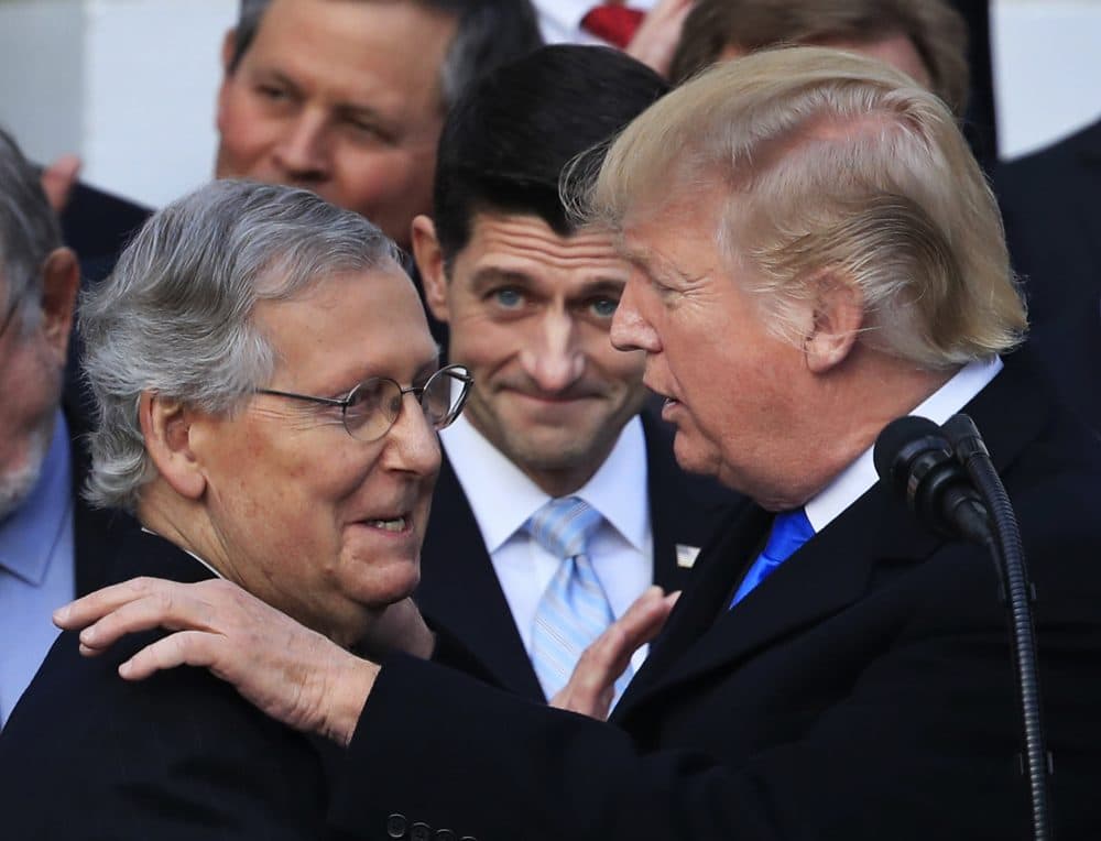 President Trump congratulates Senate Majority Leader Mitch McConnell of Ky., while House Speaker Paul Ryan of Wis., watches to acknowledge the final passage of tax overhaul legislation by Congress at the White House on Dec. 20, 2017. (Manuel Balce Ceneta/AP)