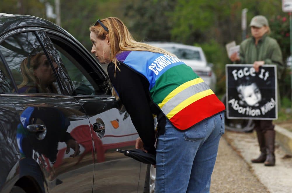Clinic escort Kim Gibson speaks with driver as they attempt to enter the Jackson Women's Health Organization's clinic parking lot, the only facility in the state that performs abortions, Tuesday, March 20, 2018 in Jackson, Miss. (Rogelio V. Solis/AP)