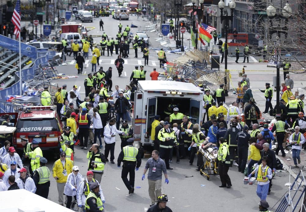 In this April 15, 2013 file photo, medical workers aid injured people following explosions at the finish line of the Boston Marathon. (Charles Krupa/AP)