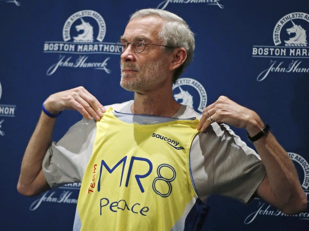 1968 Boston Marathon champion Amby Burfoot holds up a singlet during a news conference in Boston on April 17, 2014. Burfoot will wear it when he runs the Boston Marathon for the Martin Richard foundation MR8. (Elise Amendola/AP)