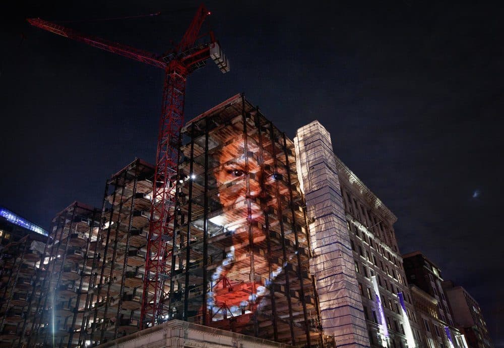 An image of former state Sen. Linda Dorcena Forry projected on a building under construction on Tremont Street. (Courtesy Erik Jacobs)