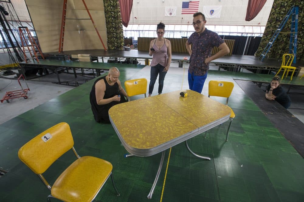 Melanie Becaling, Julie Lagevin and Bruno Baker work on the props for the stage. (Jesse Costa/WBUR)