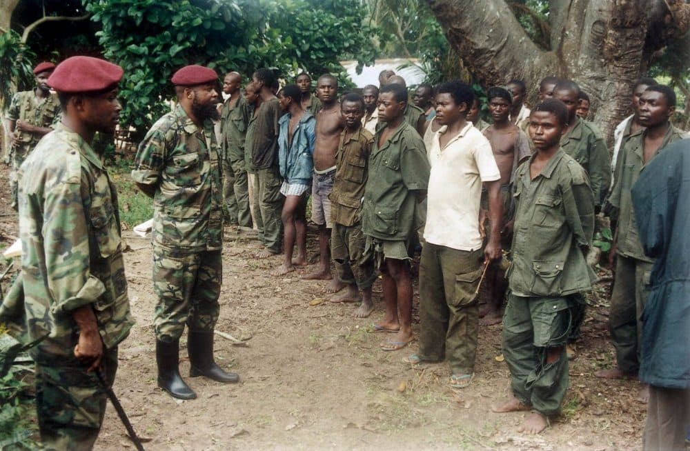 Rebels of the Movement for the Liberation of Congo, in red berets, inspect government prisoners of war in August 2000. (Cranimer Mugerwa/AP)