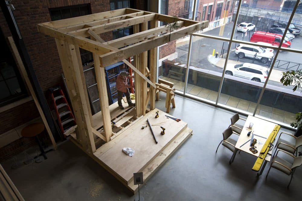 Dan Brownwood, of North Bennet Street School's preservation carpentry program, installs a splayed panel in what will become a full-scale reproduction of John Hancock's home's entryway. (Jesse Costa/WBUR)