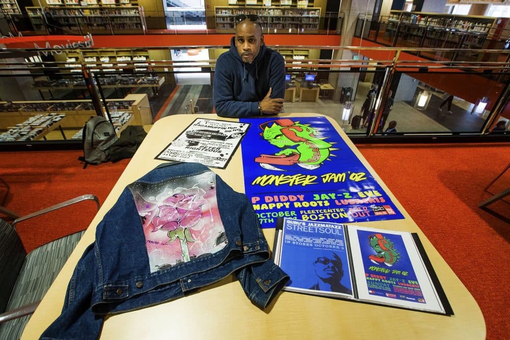 Rob Stull with posters he designed for various Boston hip-hop shows. (Jesse Costa/WBUR)