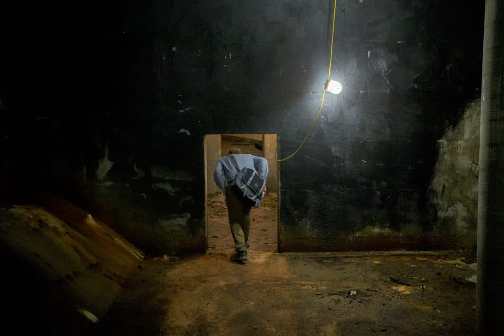 Bagley ducks through a small doorway into the rear section of the tunnel. (Jesse Costa/WBUR)