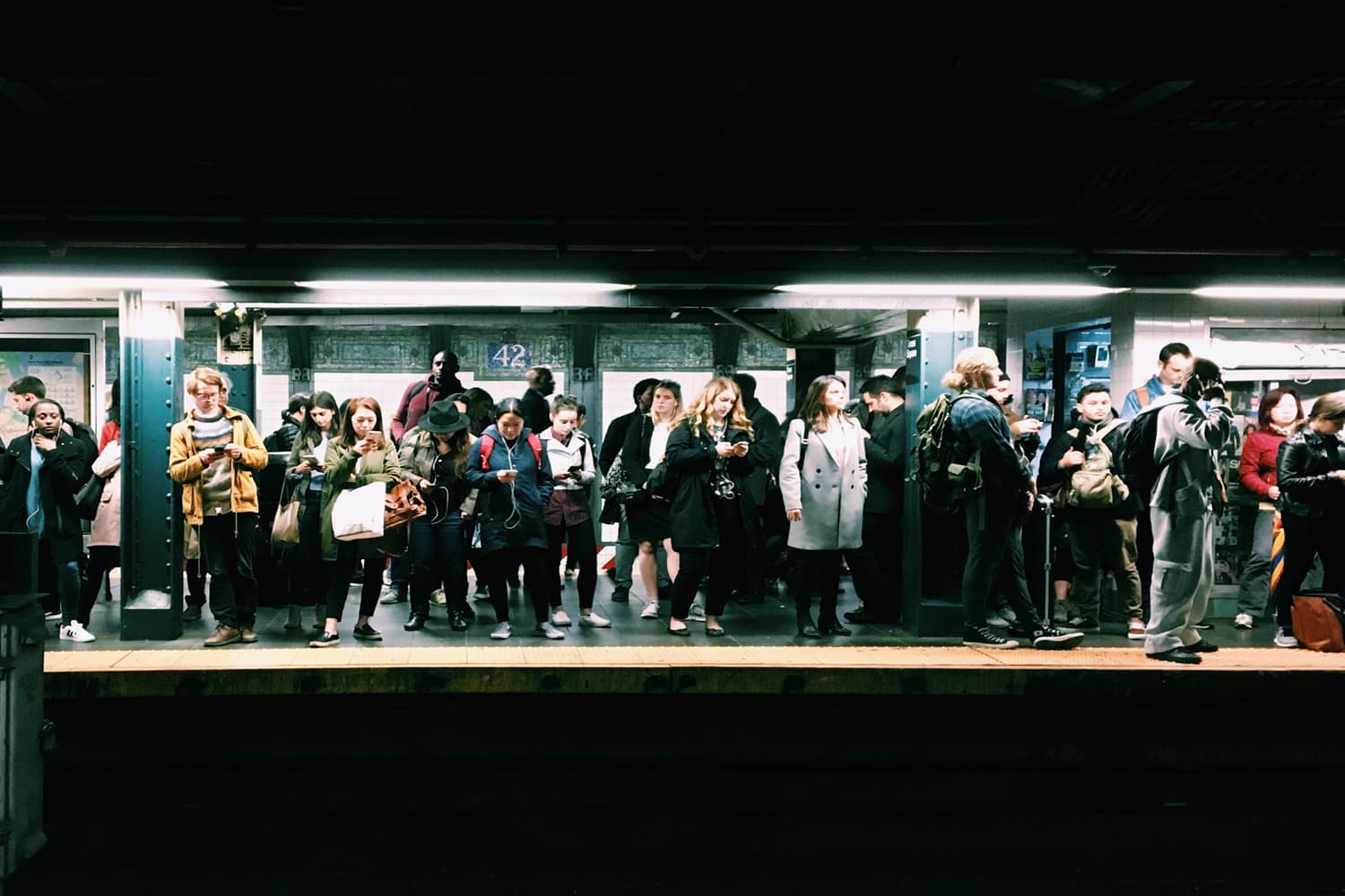 A crowd waiting for the train in the New York City subway. (Eddi Aguirre/Unsplash)