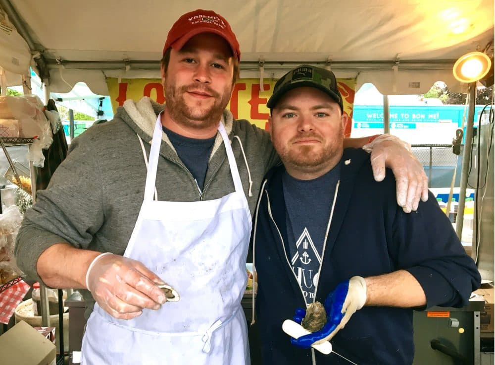 Luke Amos and Aaron Skillman were on hand to crack open some 5,000 oysters over the weekend. (Andrea Shea/WBUR)