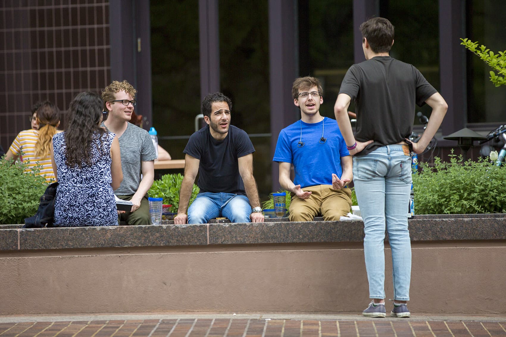 What "language" are they speaking? People outside of the Whitehead Institute for Biomedical Research in Kendall Square enjoy conversation during lunch. (Jesse Costa/WBUR)