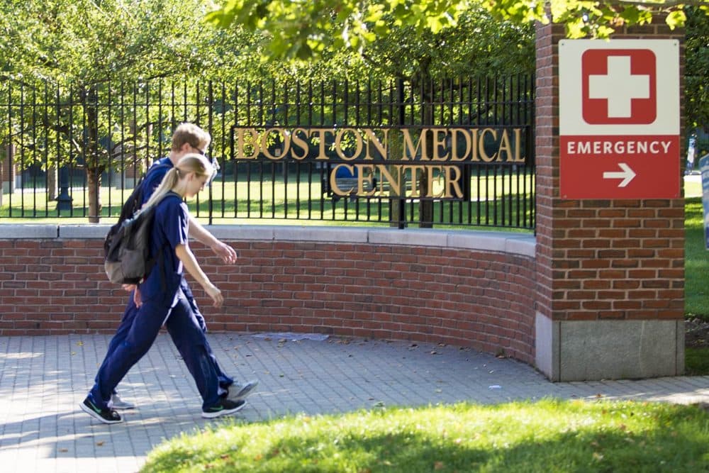 Medical personnel enter Boston Medical Center through the emergency entrance gate on Harrison Avenue. (Jesse Costa/WBUR)