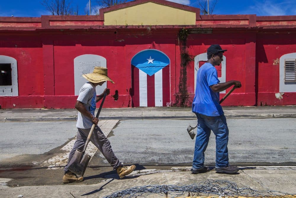 Beach workers walk along a street in Punta Santiago. (Jesse Costa/WBUR)