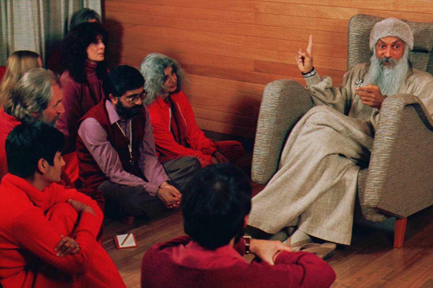 Bhagwan Shree Rajneesh, right, speaks with his disciples in this undated photo in Rajneeshpuram, Ore. (Jack Smith/AP)