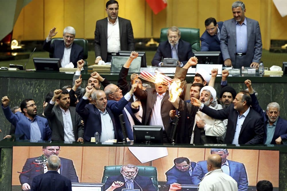 Iranian lawmakers burn two pieces of papers representing the U.S. flag and the nuclear deal as they chant slogans against the U.S. at the parliament in Tehran, Iran, Wednesday, May 9, 2018. President Donald Trump withdrew the U.S. from the deal on Tuesday and restored harsh sanctions against Iran. (AP)