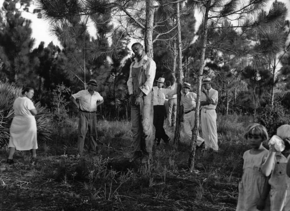 The body of 32-year-old Rubin Stacy hangs from a tree in Fort Lauderdale, Fla., as neighbors visit the site July 19, 1935. Stacy was lynched by a mob of masked men who seized him from the custody of sheriff's deputies for allegedly attacking a white woman. (AP)