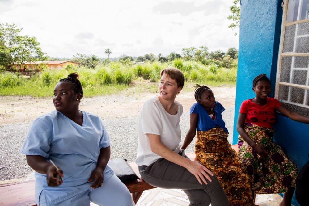 The author, Ophelia Dahl (center), and nurse Ndamba Mansaray (left) visit with Isah Kaimoko (second from right) and Kumba Finohtwo, two pregnant women staying at the Wellbody Birth Waiting Home in Kono, Sierra Leone, on Oct. 24, 2017. (Jon Lascher/Partners In Health)