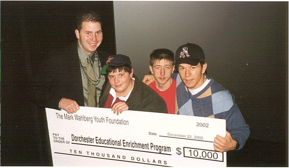 Mark Wahlberg, right, presents a check to Project DEEP, a Dorchester nonprofit, around 2002. From left, Project DEEP’s John Hanlon, and brothers Tim and Joey Langis of Dorchester. (Courtesy)