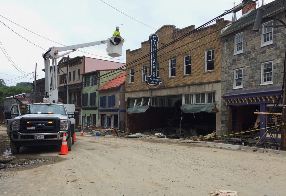 Utility workers check the power lines on Main Street after Sunday's floodwaters that raged down the downtown district in Ellicott City, Md., Tuesday, May 29, 2018. (Courtney Columbus/AP)