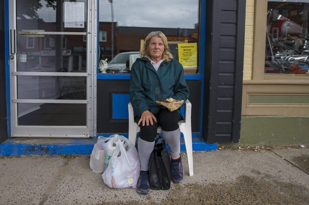 Debra Kimberly Findlay sits in a chair in front of the Mission Restaurant in downtown Smiths Falls. Finley says she has no interest in a marijuana job, and that the arrival of Canopy is only reinforcing the town's image as a down-on-its luck kind of place. &quot;They'll just call it the 'Dope Town,' &quot; she says. (Jesse Costa/WBUR)