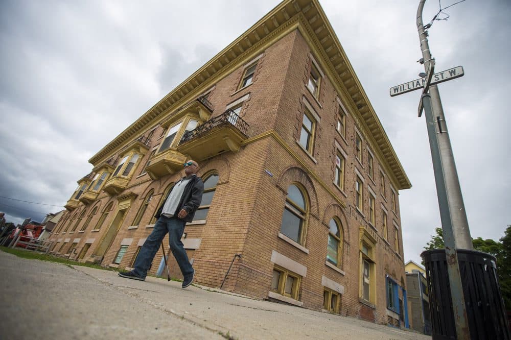 A man walks by the abandoned Hotel Rideau in downtown Smiths Falls. (Jesse Costa/WBUR)