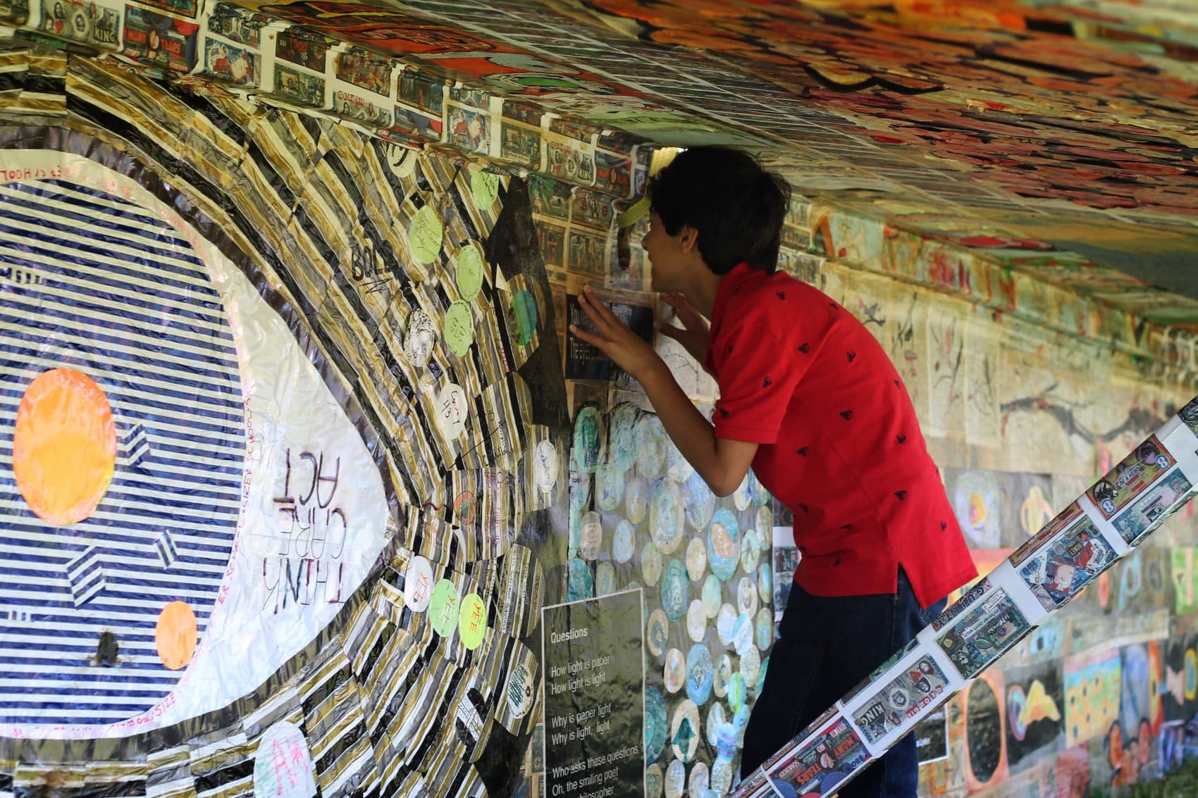 Manolo Barroso, from Quincy, takes a closer look at the paper airplane. (Amy Gorel/WBUR)