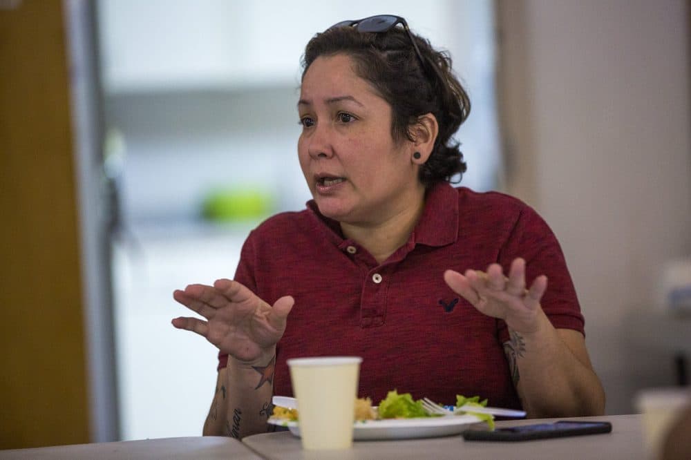 Dagamer Rivera talks with other evacuees about their housing situations. (Jesse Costa/WBUR)