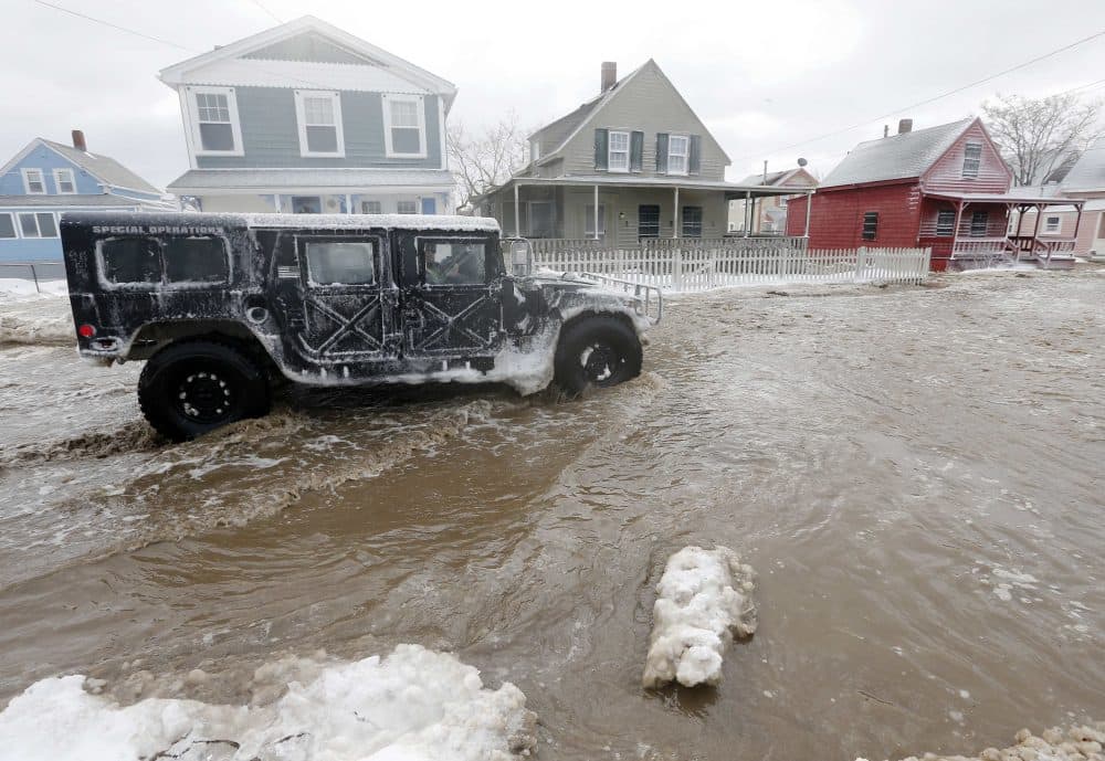 A police special operations vehicle drives down a flooded street along the shore in Hull, Mass., Friday, Jan. 3, 2014, in the wake of a winter storm. (Michael Dwyer/AP)