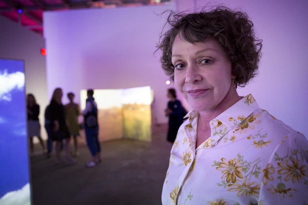 Artist Diana Thater, surrounded by her work, at the inaugural exhibition of the ICA Watershed in East Boston. (Robin Lubbock/WBUR)