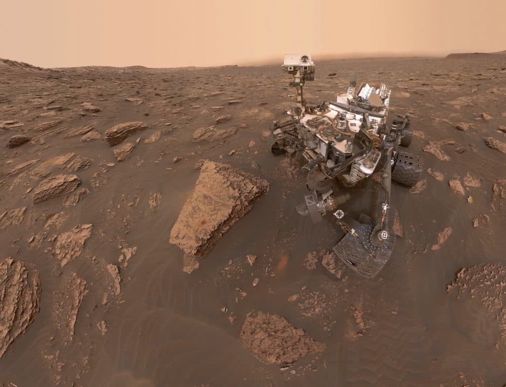 This composite image made from a series of June 15, 2018 photos shows a self-portrait of NASA's Curiosity Mars rover in the Gale Crater. The rover's arm which held the camera was positioned out of each of the dozens of shots which make up the mosaic. A dust storm has reduced sunlight and visibility at the rover's location. (NASA/JPL-Caltech via AP)