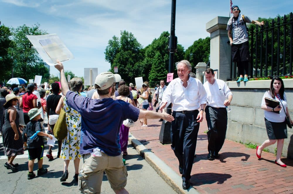 Sen. Ed Markey shakes hands with protestors marching past the State House at the &quot;Keep Families Togather&quot; rally. (Elizabeth Gillis/WBUR)