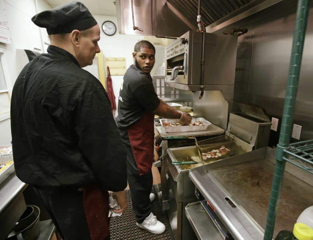 Ray'shawn Mohammed, right, prepares dinner in the culinary center while participating in a jail alternative program at Roca Inc. in Chelsea, Mass., Thursday, Jan. 12, 2017. The recidivism program at Roca seeks to steer hundreds of Massachusetts' highest-risk young men away from a return behind bars. "The first time I saw someone shot, I was in the third grade," Mohammed confided. "I was forced to grow up quicker than usual." (Charles Krupa/AP)