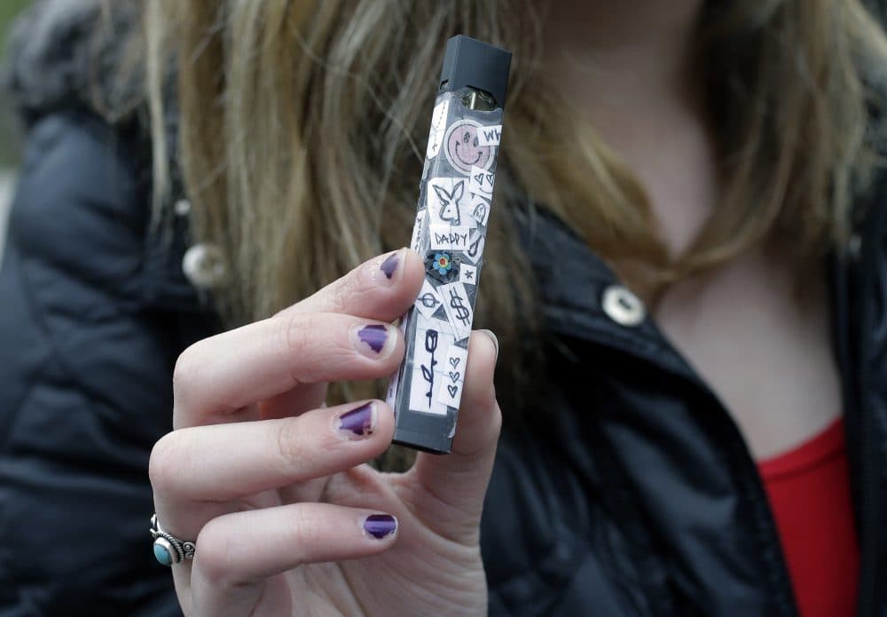 In this April 11 photo, an unidentified 15-year-old high school student displays a vaping device near her school's campus in Cambridge. (Steven Senne/AP)