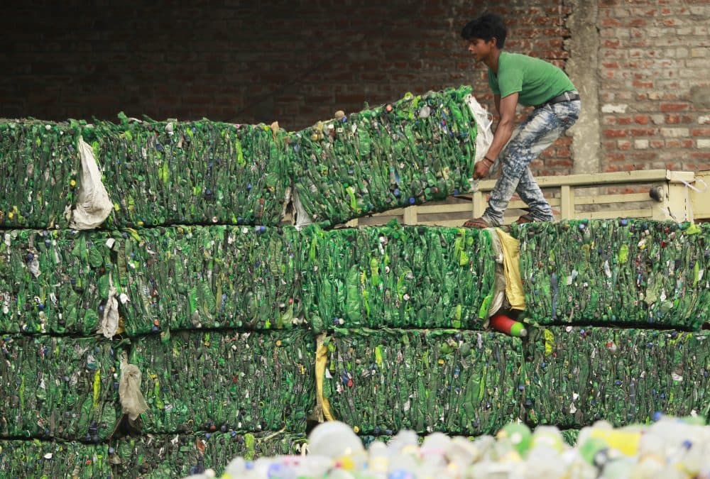An Indian worker loads bundles of plastic bottles onto a truck for recycling at an industrial area on the outskirts of Jammu, India, on June 5. The U.N. says government bans on plastic can be effective in cutting back on waste but poor planning and follow-through have left many such bans ineffective. (Channi Anand/AP)