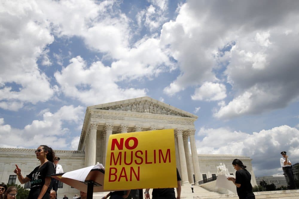 People protest Tuesday against the Supreme Court ruling upholding President Trump's travel ban. (Jacquelyn Martin/AP)