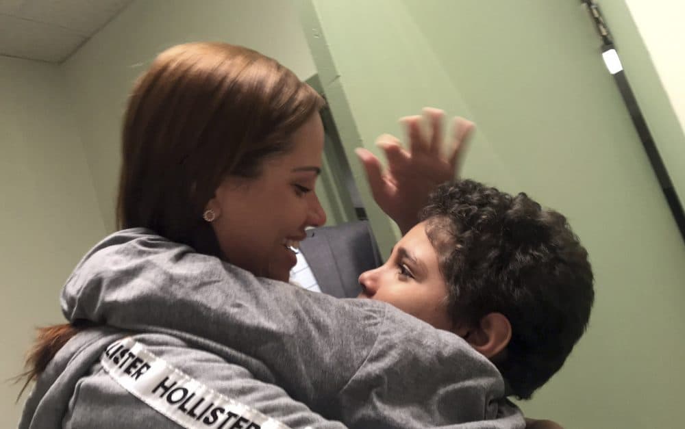 In this photo provided by paralegal Luana Mazon, Lidia Karine Souza, 27, hugs her 9-year-old son Diogo De Olivera Filho as Souza visited her son Tuesday for the first time since they were separated at the U.S.-Mexico border in late May. (Courtesy of Luana Mazon via AP)