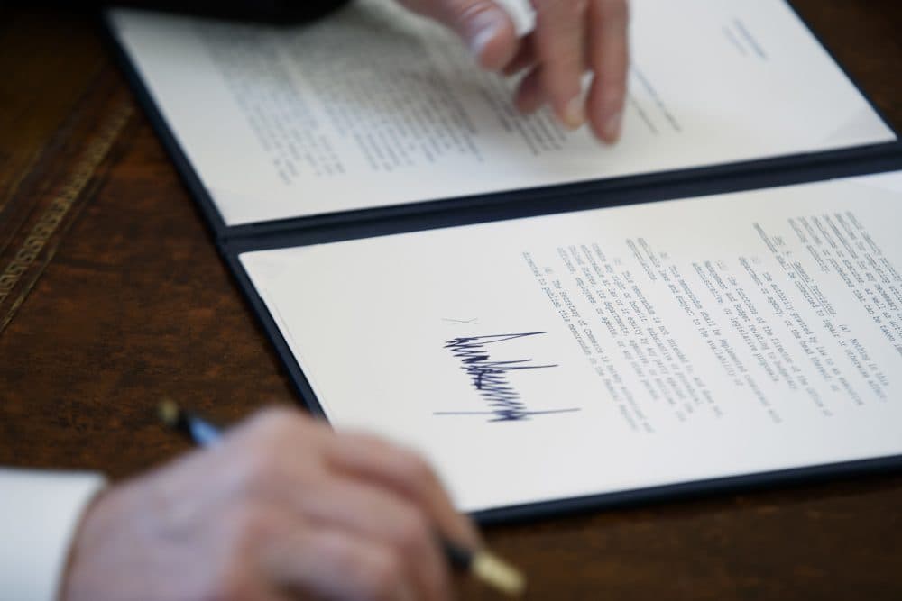 In this Jan. 24, 2017, file photo, the signature of President Donald Trump is seen on an executive order in Oval Office of the White House in Washington. Trump has taken 18 executive actions since being sworn into office on Jan. 20. Some of the papers he signed were executive orders that dealt with building the wall he promised along the U.S.-Mexico border; temporarily banning entry to the U.S. by refugees and people from seven majority-Muslim nations; and beginning to chip away at the Affordable Care Act. (AP Photo/Evan Vucci, File)