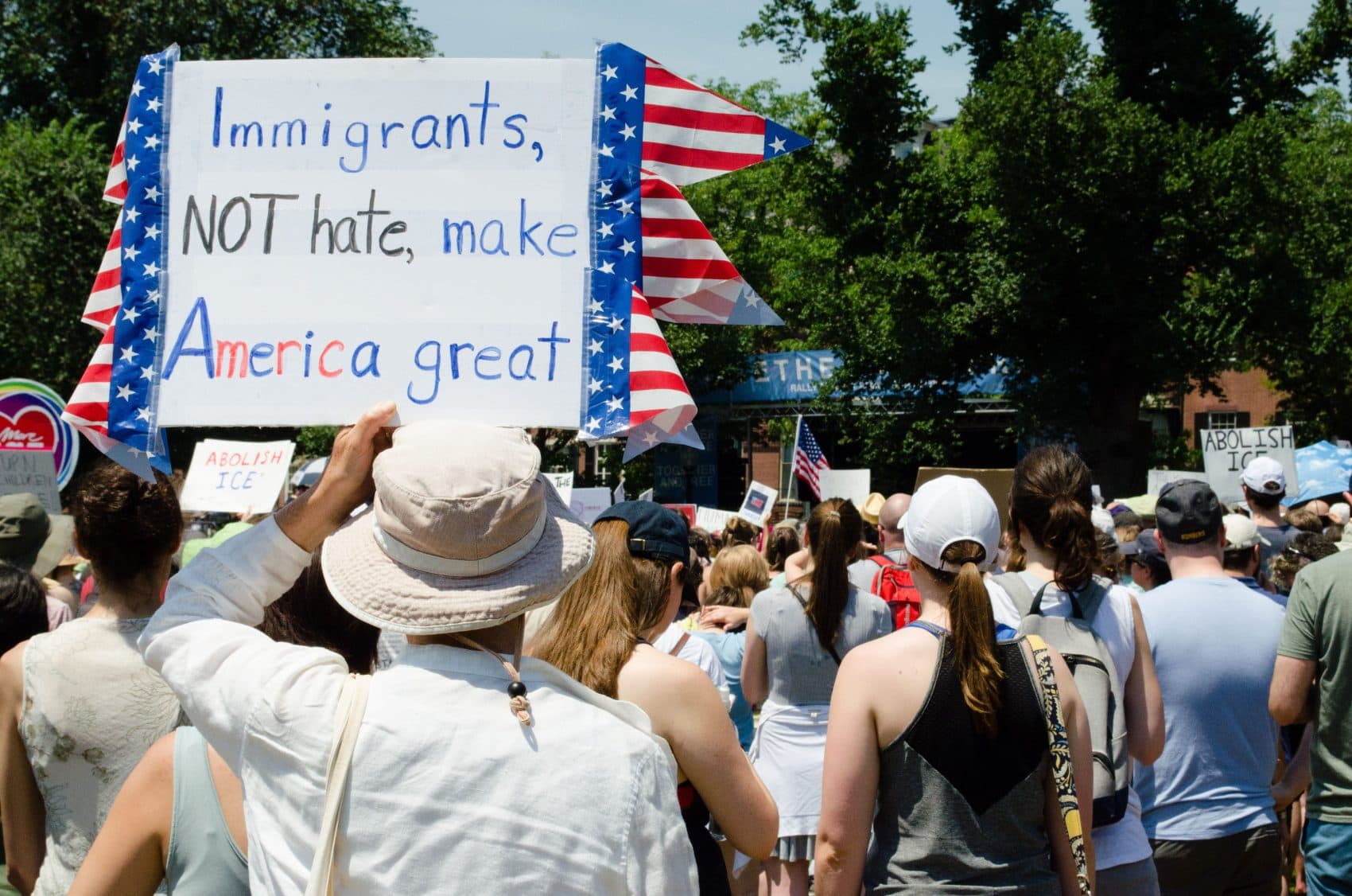 A man holds a sign at an immigration rally in Boston on June 30, 2018. (Elizabeth Gillis/WBUR)