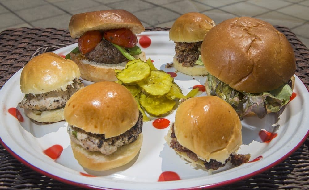 A plate of assorted burgers. (Clockwise from top left) the Classic burger, the Superiority burger, and the Turkey-feta burger. (Jesse Costa/WBUR)