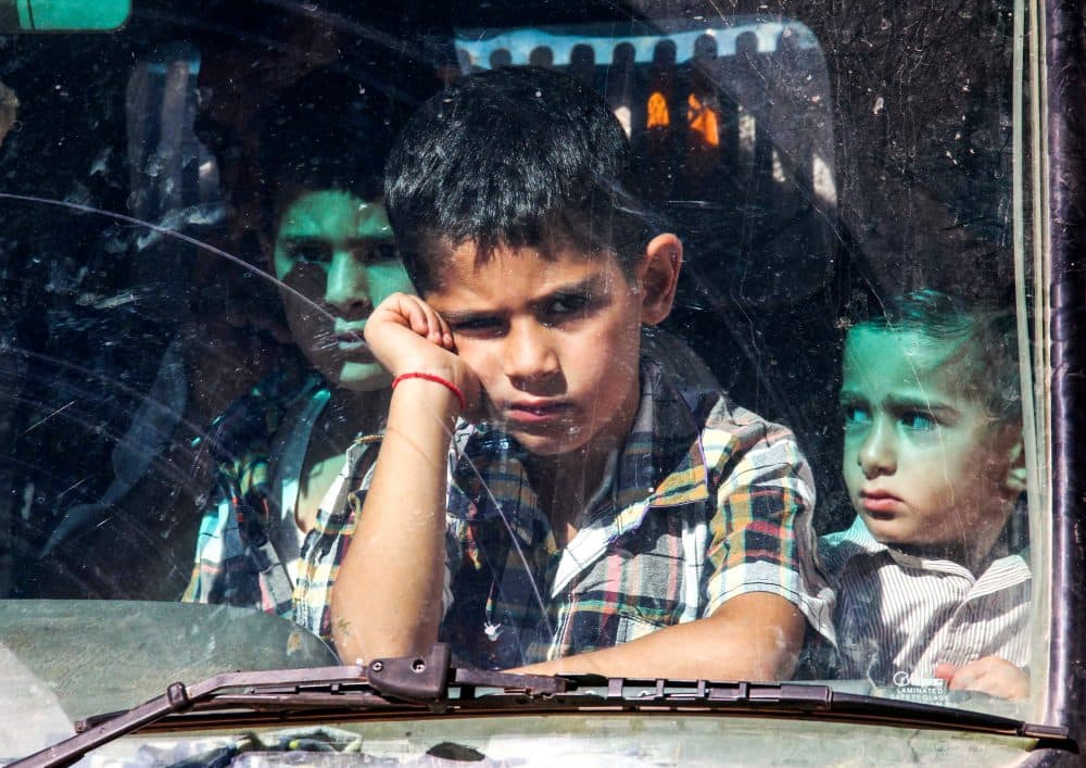 Syrian refugee children ride in a bus as they are evacuated from the southern Lebanese village of Shebaa on July 28, 2018, to return to Syria. (Ali Dia/AFP/Getty Images)