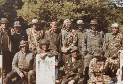 Charles' and Hayes' 12-man paintball squad poses with the final leaderboard. (Courtesy Ritchie White)