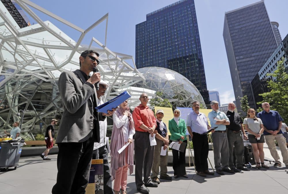 Shankar Narayan, legislative director of the ACLU of Washington, left, speaks at a news conference outside Amazon headquarters, Monday, June 18, 2018, in Seattle. Representatives of community-based organizations urged Amazon to stop selling its face surveillance system, Rekognition, to the government. They later delivered the petitions to Amazon. (Elaine Thompson/AP)